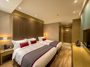 A hotel room with two beds, a bedside table with a phone and a lamp, a wooden floor, and a wall-mounted TV. - SHANGHAI-DECO Hotel (Shanghai)