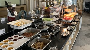 A buffet setup with various food items and utensils. - SHANGHAI-DECO Hotel (Shanghai)