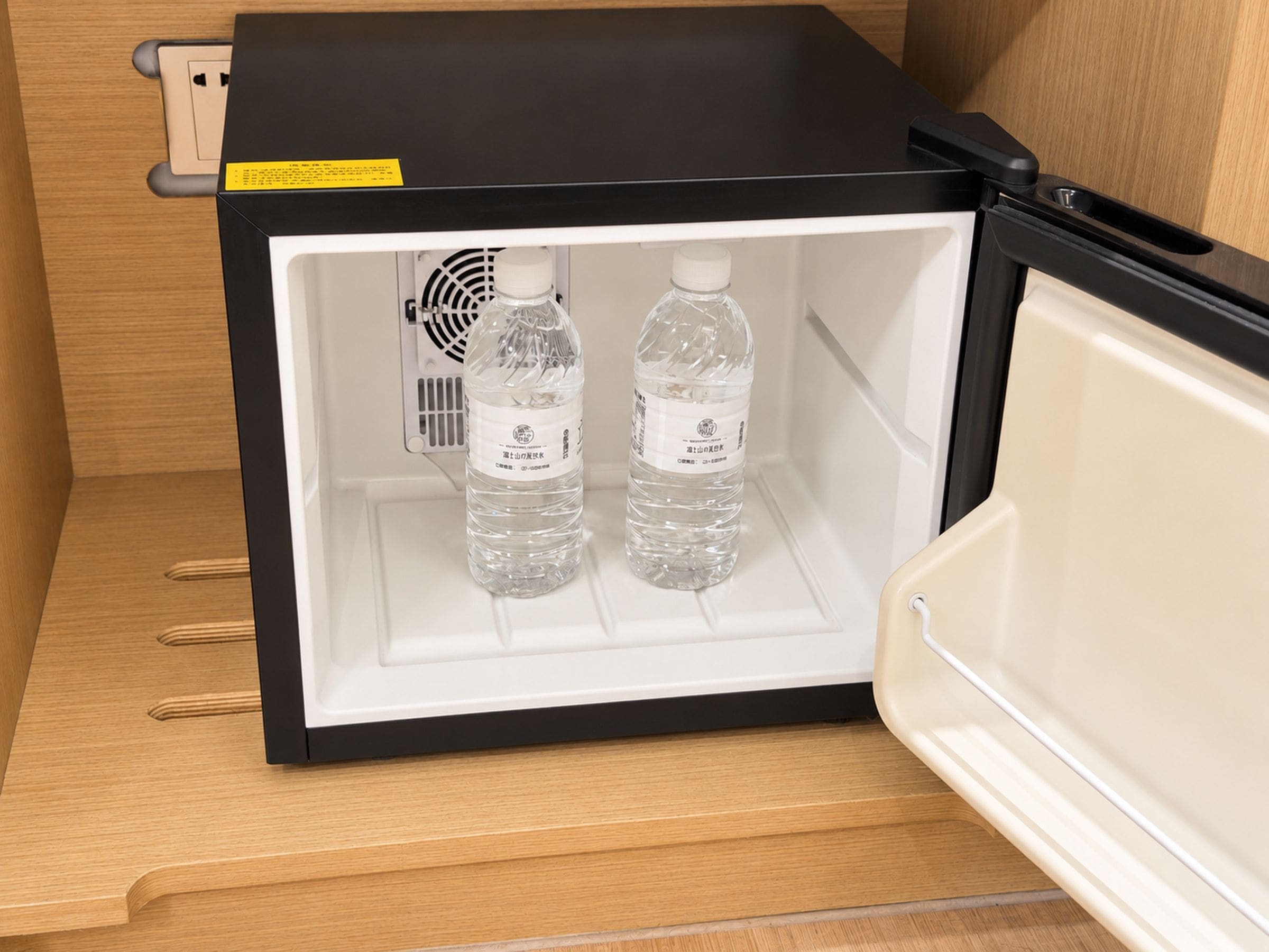A refrigerator with two water bottles inside.
