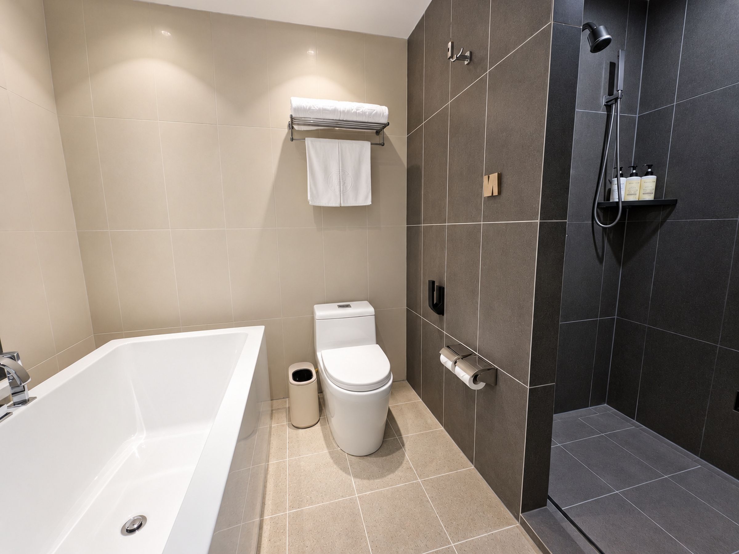 A modern bathroom with a bathtub, toilet, and shower.