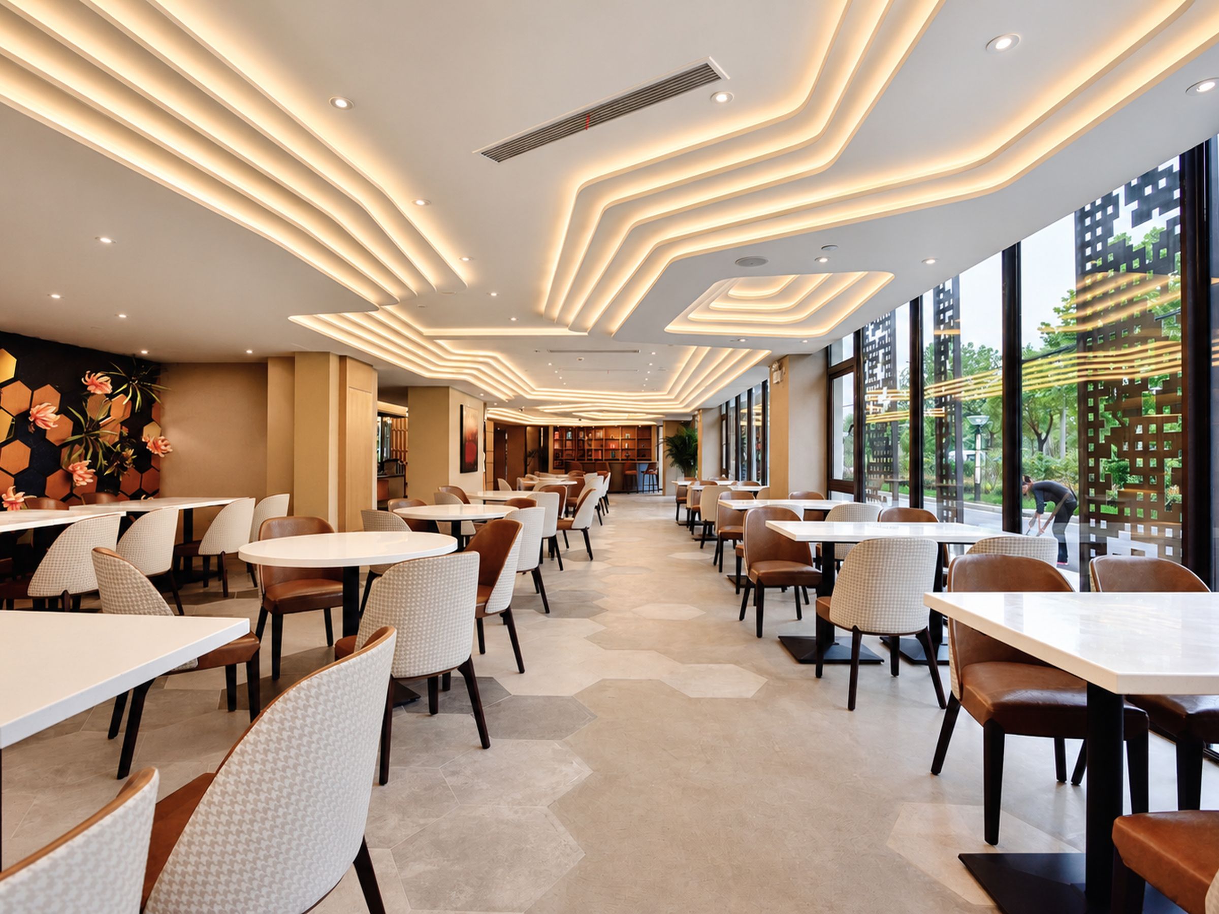 A modern restaurant interior with a long counter and multiple seating areas.