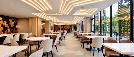 A modern restaurant interior with a long counter and multiple seating areas.