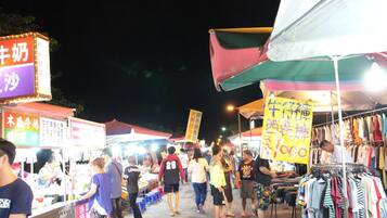 A crowded outdoor market with various stalls and people.