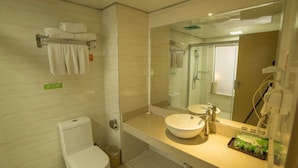 Un baño moderno con inodoro, lavamanos y ducha.