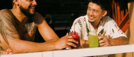 Two individuals seated at a counter with drinks, suggesting a social setting.