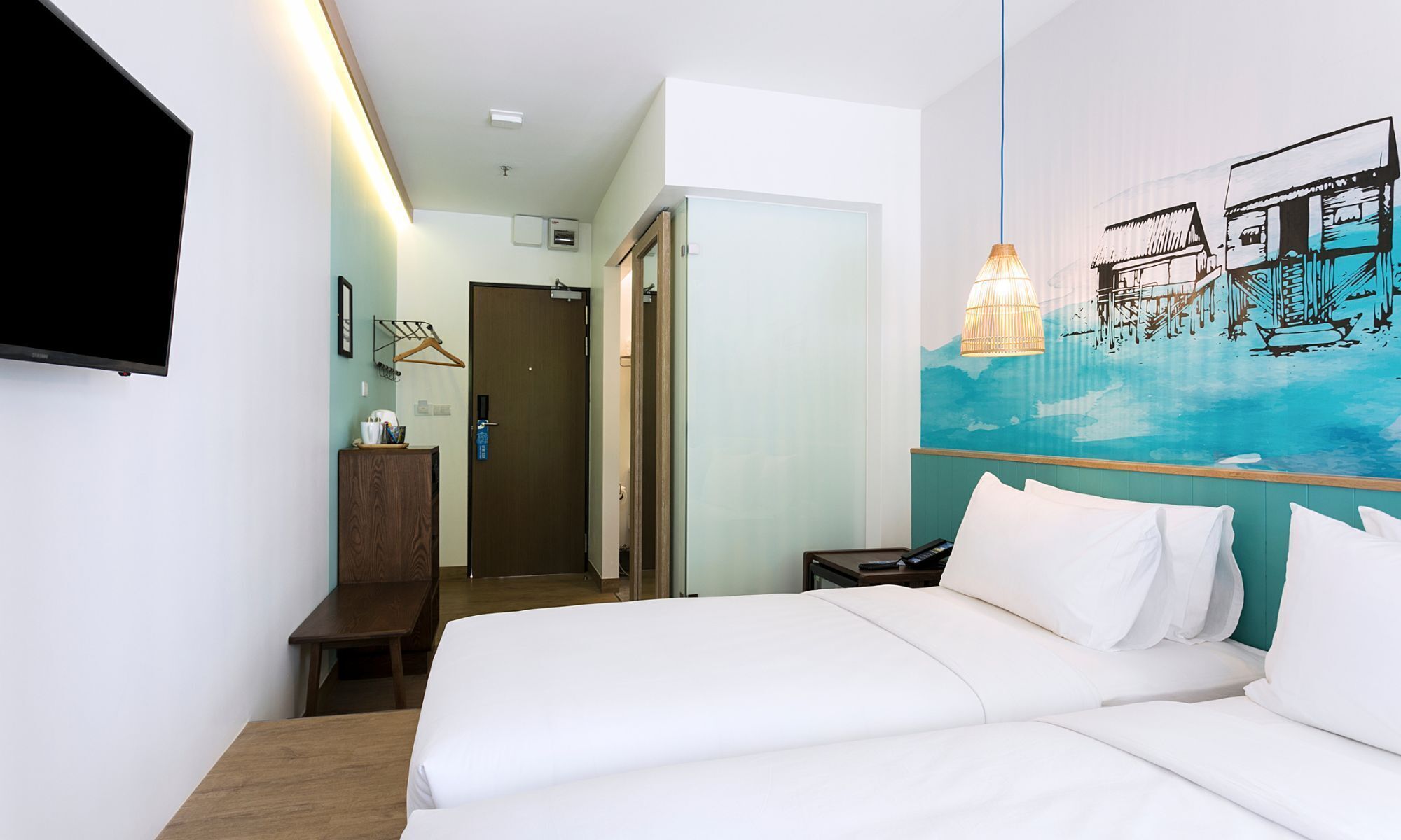 A hotel room with a bed, a desk, a chair, a TV, and a painting on the wall.