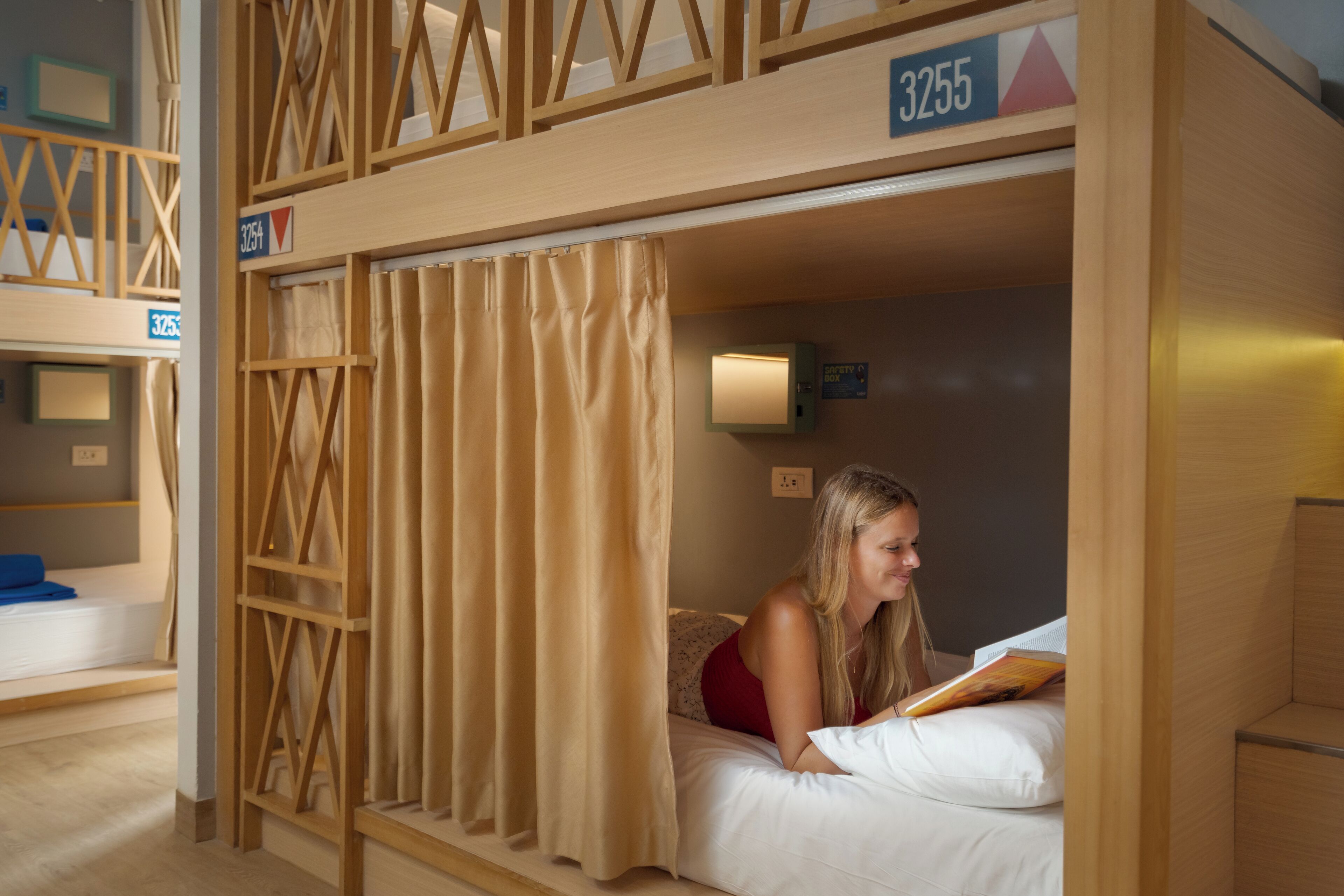 A bunk bed with a number 3255, a wooden ladder, and a curtain.