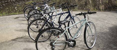 A row of bicycles parked against a stone wall.