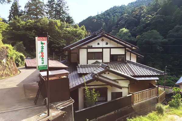 Un edificio de estilo japonés tradicional con un letrero que indica que es un albergue.
