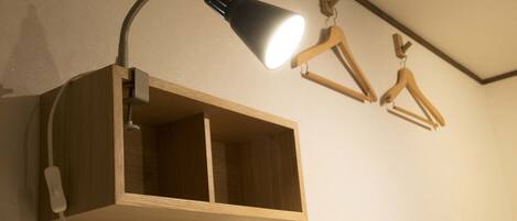A wall-mounted wooden cabinet with a desk lamp and a power strip.