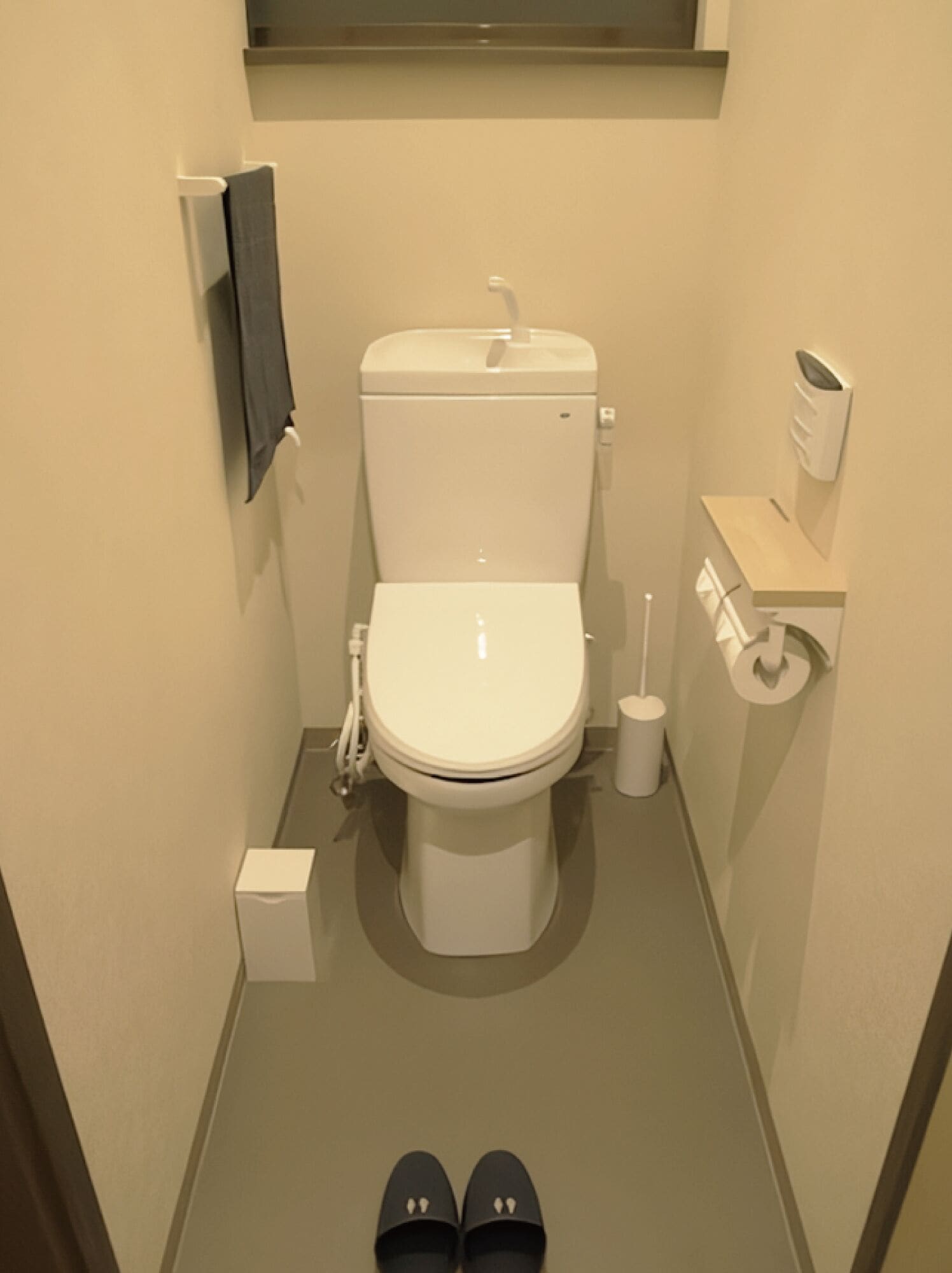 Ein kleines Badezimmer mit Toilette, einem Wäscheständer und einem Toilettenpapierhalter.