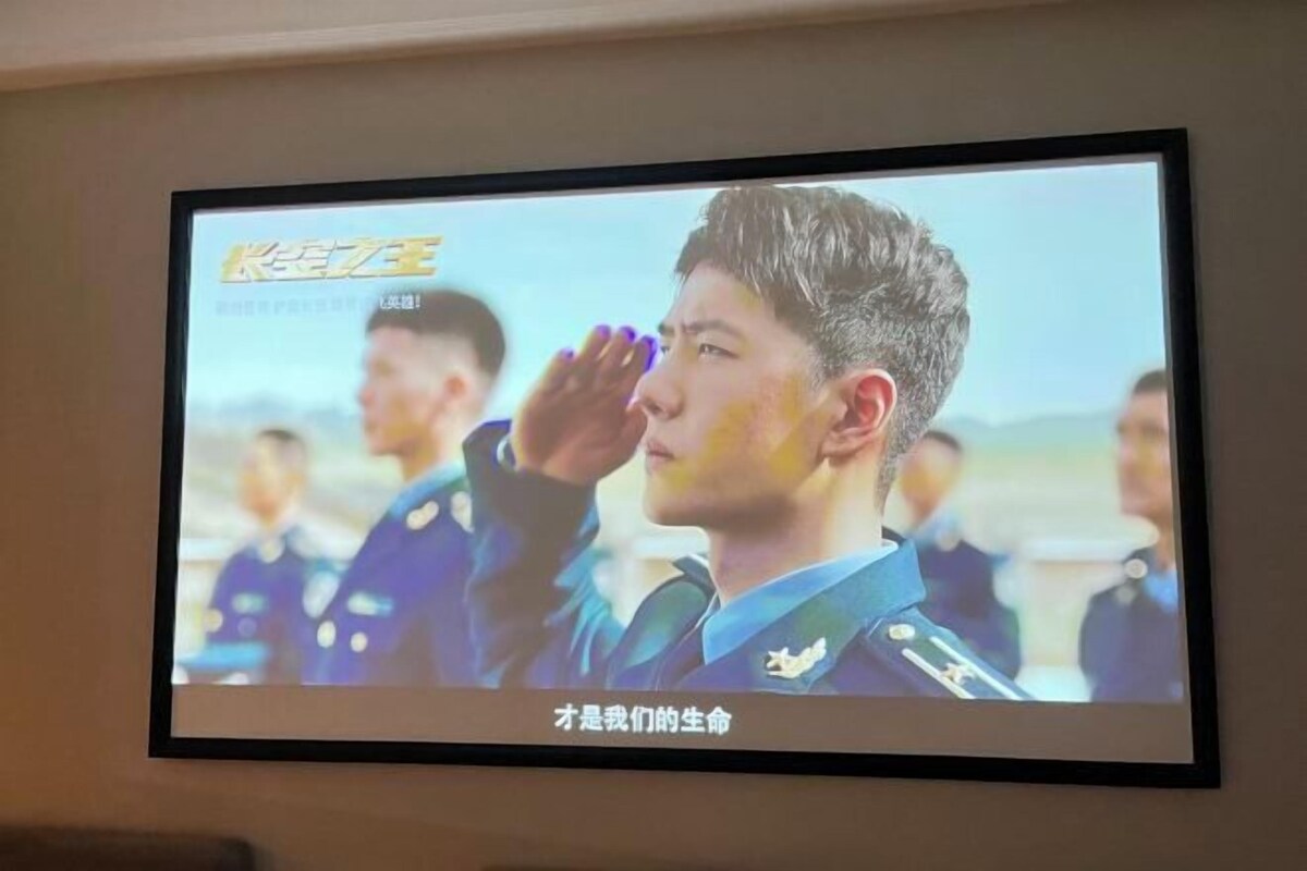 Una pantalla de televisión mostrando una escena con personas con uniforme, posiblemente en un contexto militar o ceremonial.