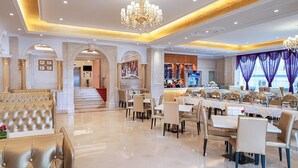A luxurious dining area with a chandelier, elegant seating, and a view of the city. - Vienna International Hotel （Longgang Universiade Center Subway Station） (Shenzhen)