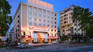 A large hotel with a prominent sign, multiple floors, and a classic architectural style. - Vienna International Hotel （Longgang Universiade Center Subway Station） (Shenzhen)