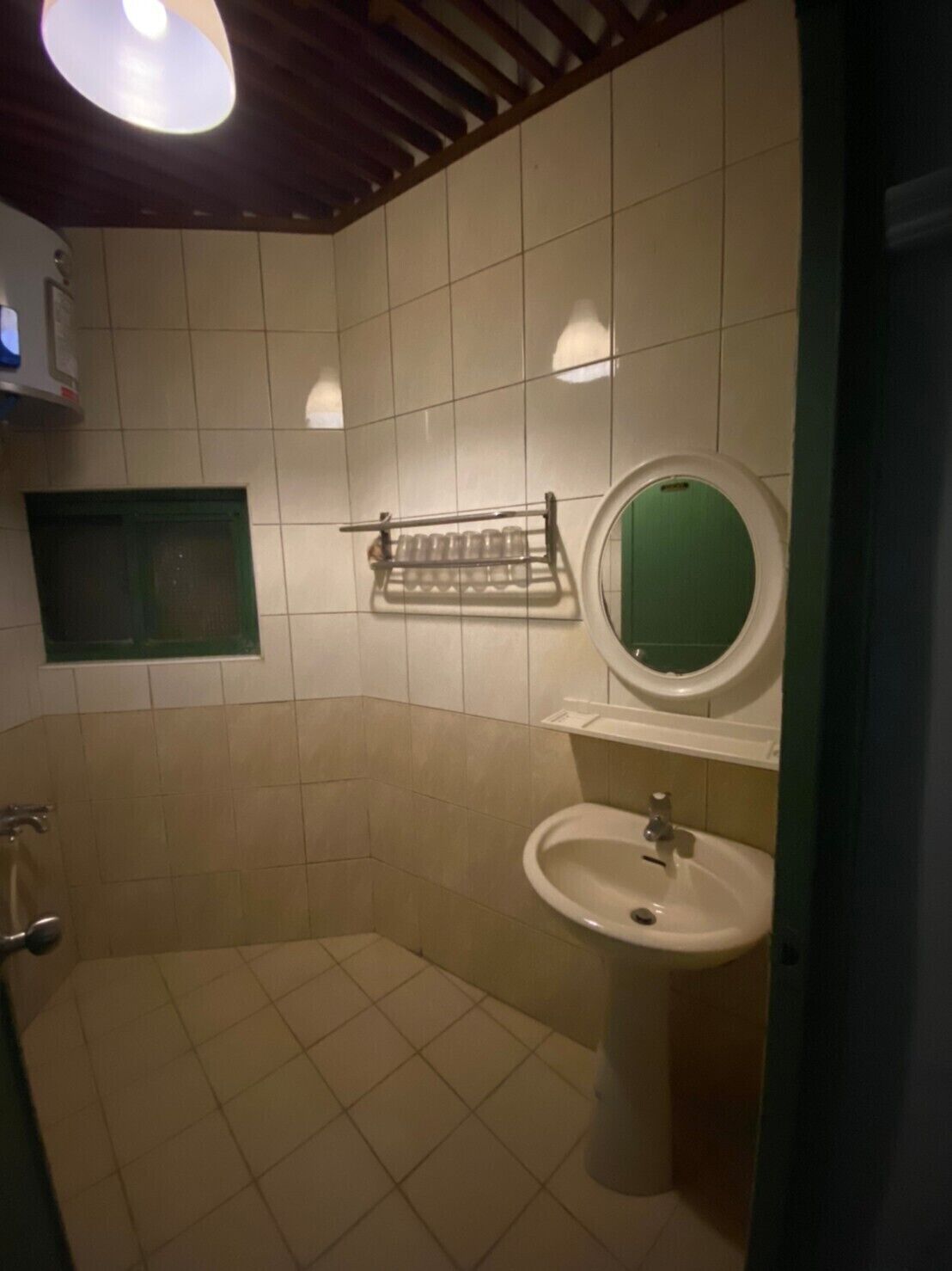Un baño pequeño con inodoro, lavamanos y espejo.