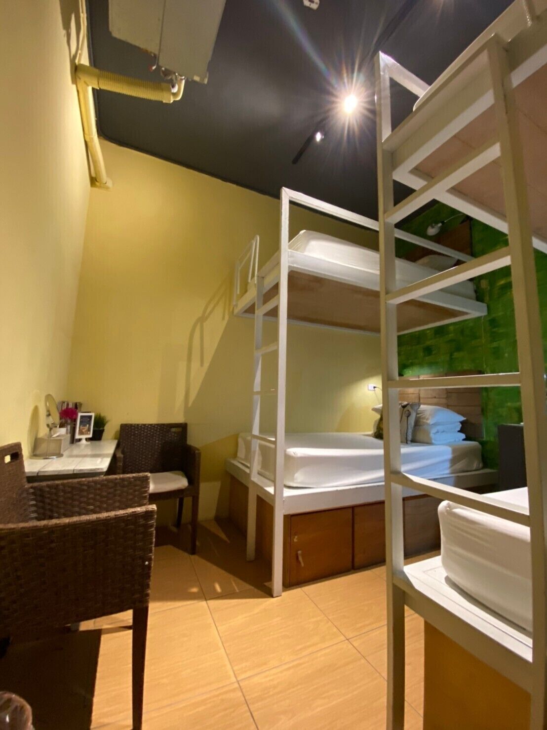 A room with bunk beds, a desk, and a chair.