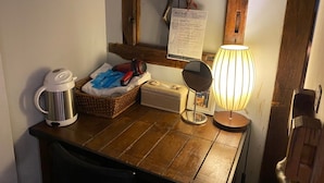 A wooden counter with a kettle, a basket, a mirror, and a lamp. - Good Farming Day B&B (Chishang)