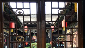 A traditional Chinese gate with intricate designs and a red banner above. - Pingyao Yuchengyuan Hotel (Jinzhong)