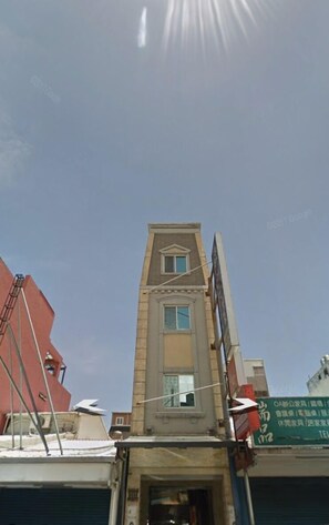 A multi-story building with a central entrance and a visible upper window.