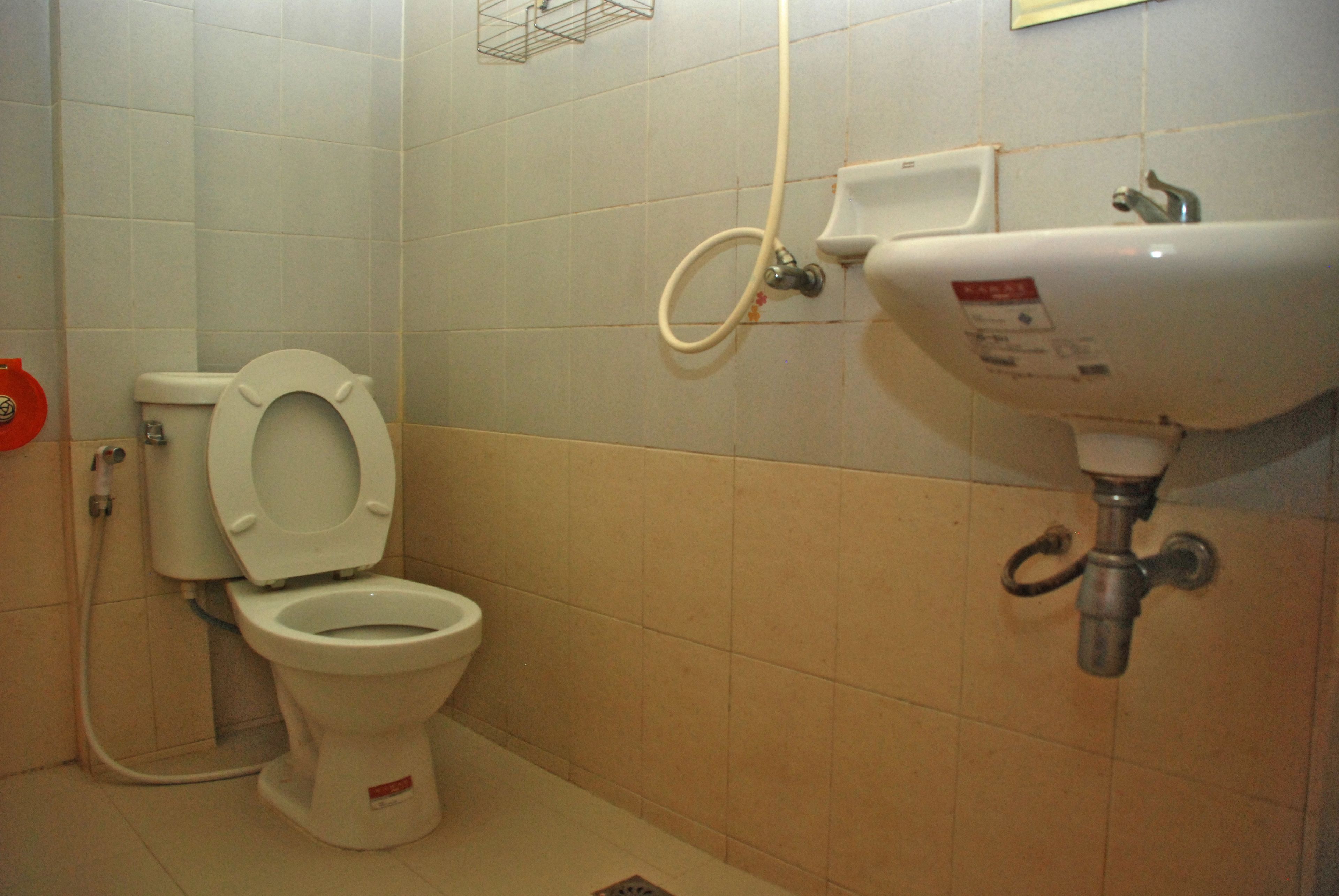 A standard bathroom with a toilet, sink, and shower.