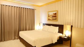 Ein Hotelzimmer mit einem großen Bett, einem Nachttisch mit Lampe und einem Gemälde an der Wand.