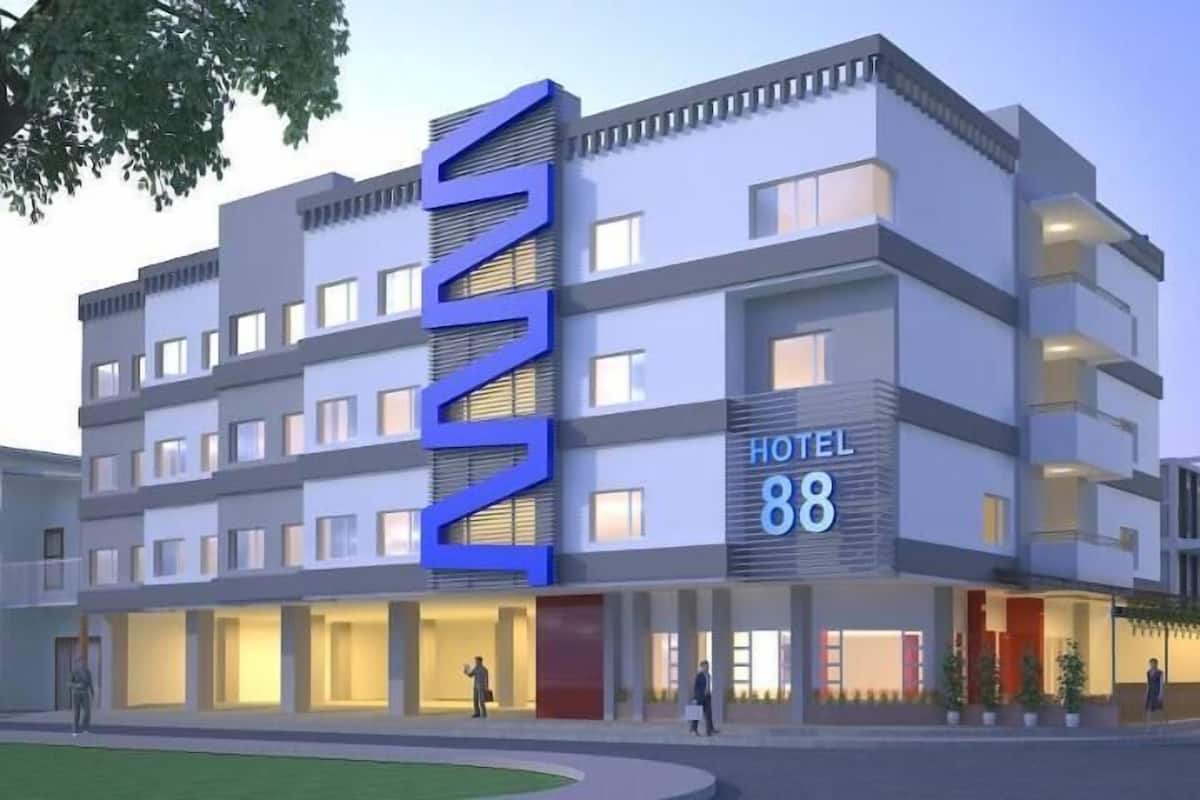 Ein mehrstöckiges Hotel mit einer auffälligen blauen Schilder und mehreren Balkonen sowie einem gut beleuchteten Eingang.
