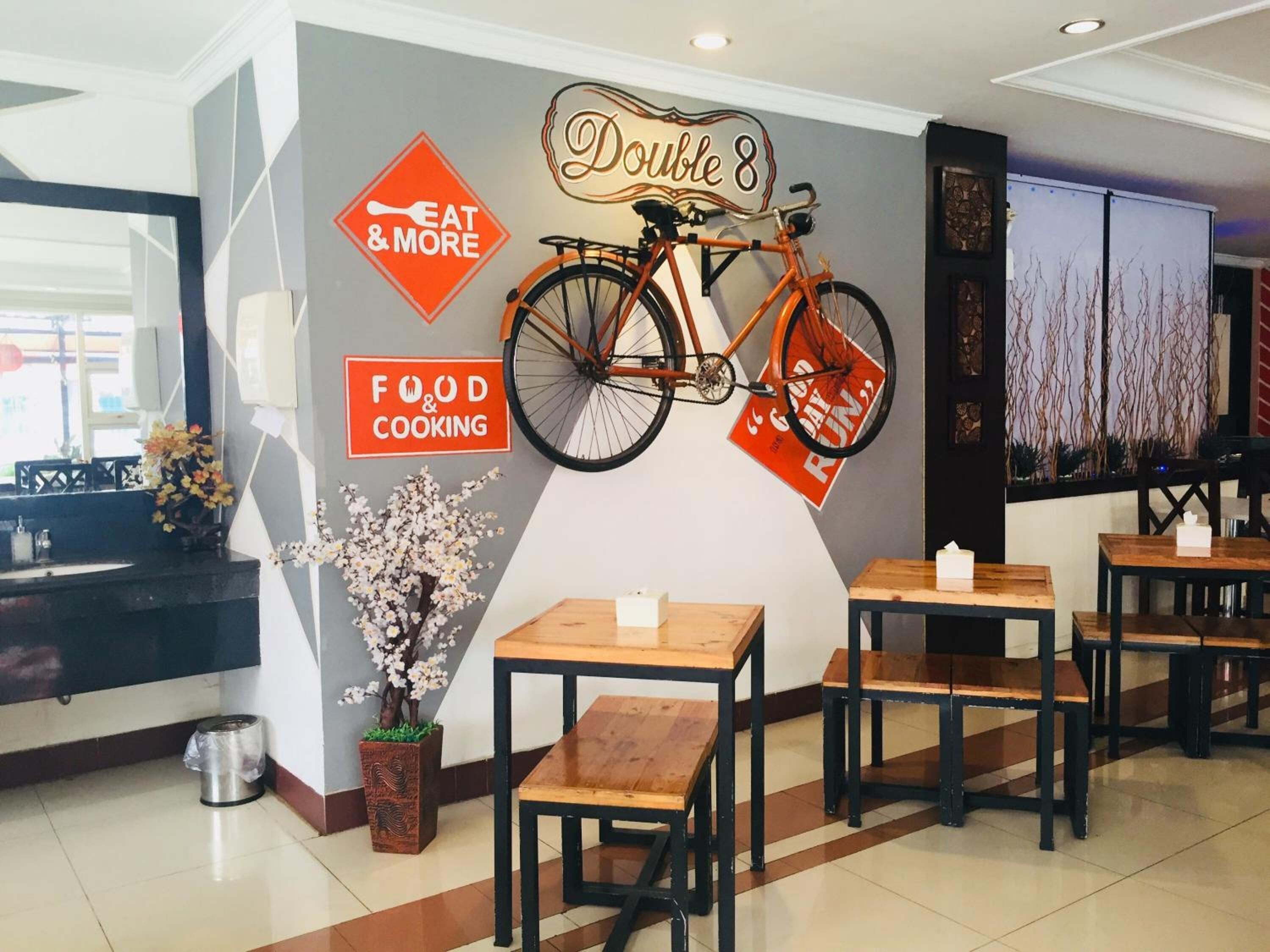 A restaurant interior with a wall-mounted bicycle, tables, and chairs.