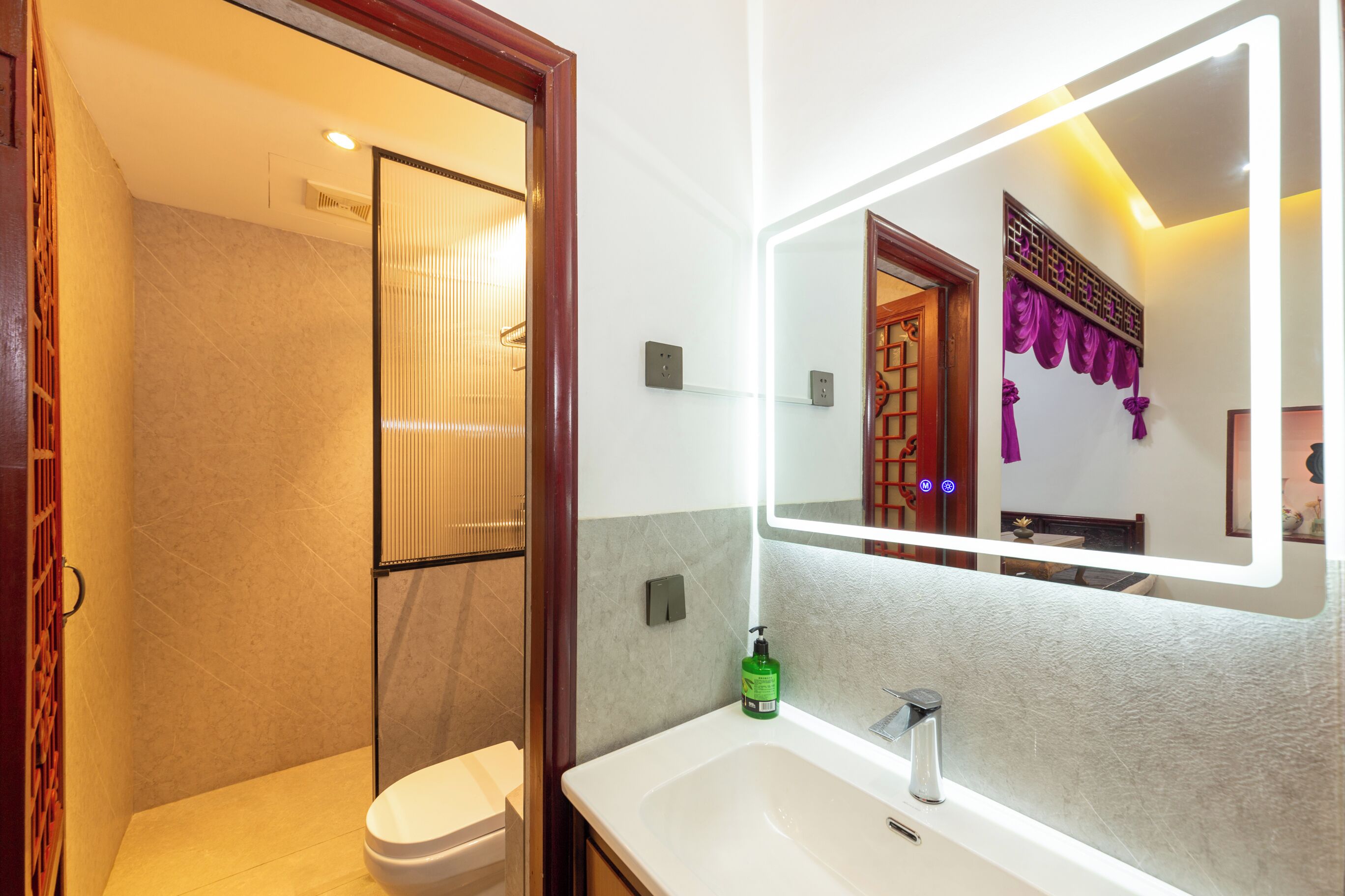 A bathroom with a white sink, a mirror, and a shower.
