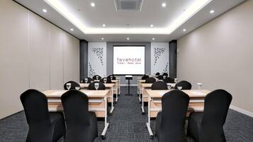 Een vergaderzaal met een projectorscherm waarop 'favehotel Tuban - East Java' staat.