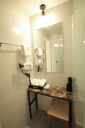 A bathroom with a marble countertop, a hairdryer, a towel rack, and a mirror. - Romantic Trip (Gyeongju)