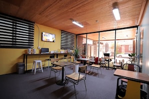 Work in comfort with desks and chairs for productivity, a computer monitor, and a coffee machine nearby.