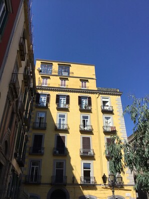 A yellow building with multiple balconies and windows, featuring a classic architectural style. - Santa Maria La Nova 21 B&B (Naples)