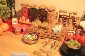 A kitchen counter with various food items, including jars of nuts, a bowl of grapes, and a container of yogurt. - Santa Maria La Nova 21 B&B (Naples)