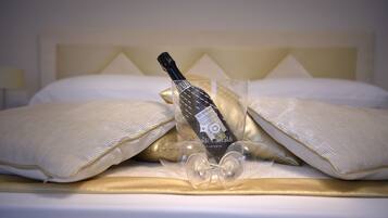 Uma cama com uma garrafa de vinho e um copo.