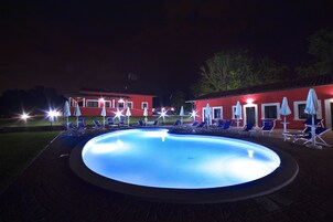 Una piscina al aire libre, sombrillas, tumbonas