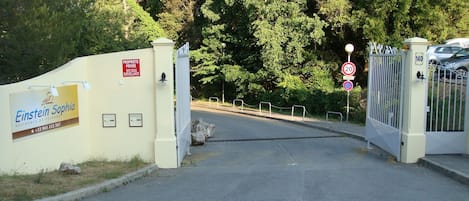 A gated entrance to a property named 'Einstein Sophia' with a sign indicating surveillance.