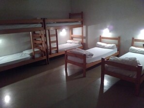 Un dormitorio con literas, una cama individual y una silla.