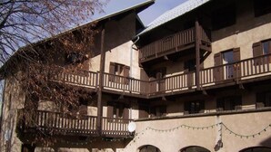 A multi-story building with balconies, arched windows, and a fence. - CapVerb (Guillestre)