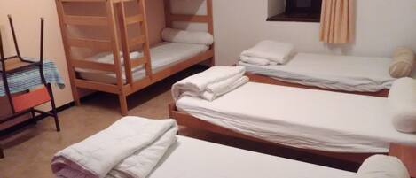 A dormitory room with bunk beds and a single bed.