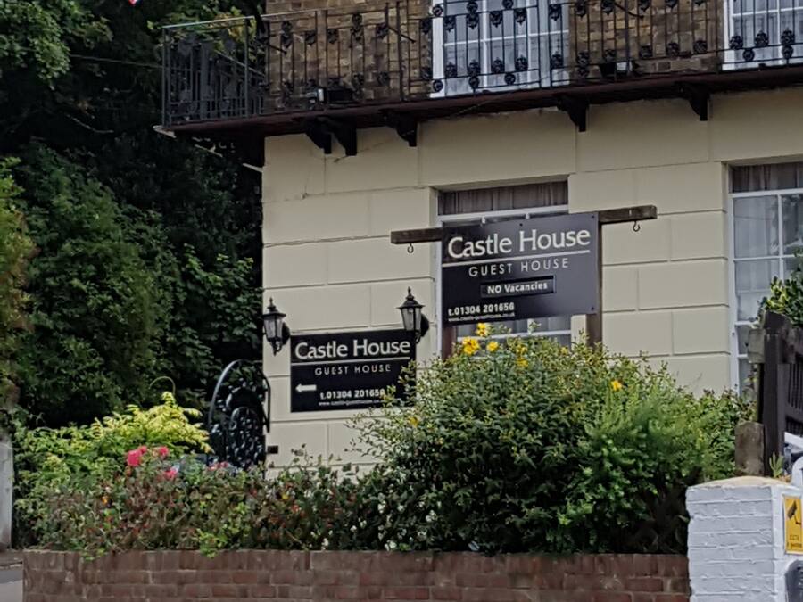 Un edificio con un cartel que dice "Castle House Guest House" y una bandera británica.
