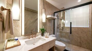 A modern bathroom with a large sink, mirror, and shower.