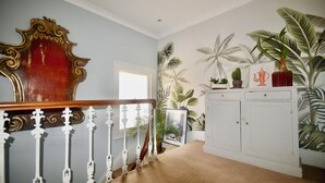 Un escalier avec une rampe blanche, une main courante en bois et une moquette beige.