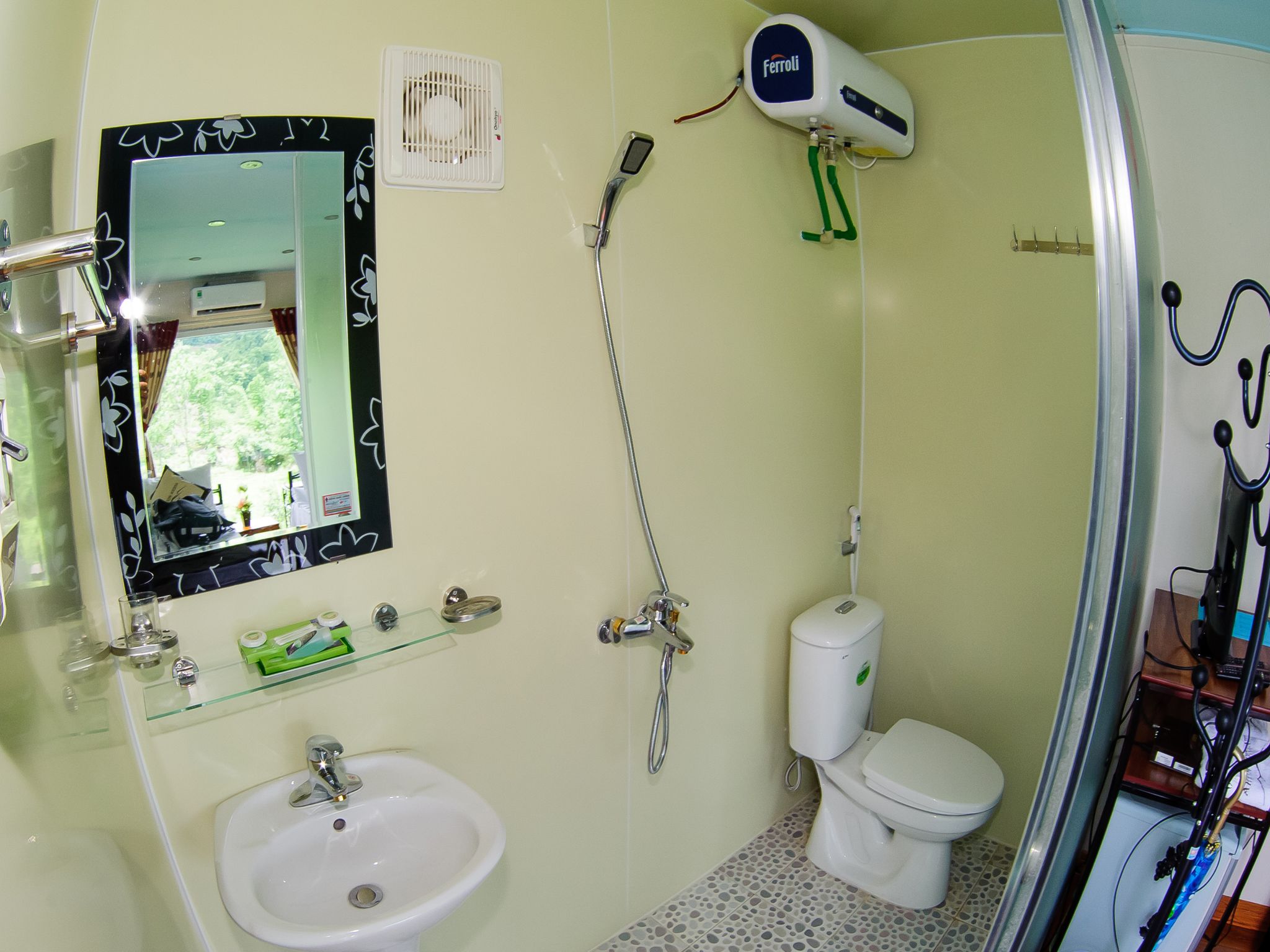 Un baño con lavamanos, inodoro y espejo con marco decorativo.