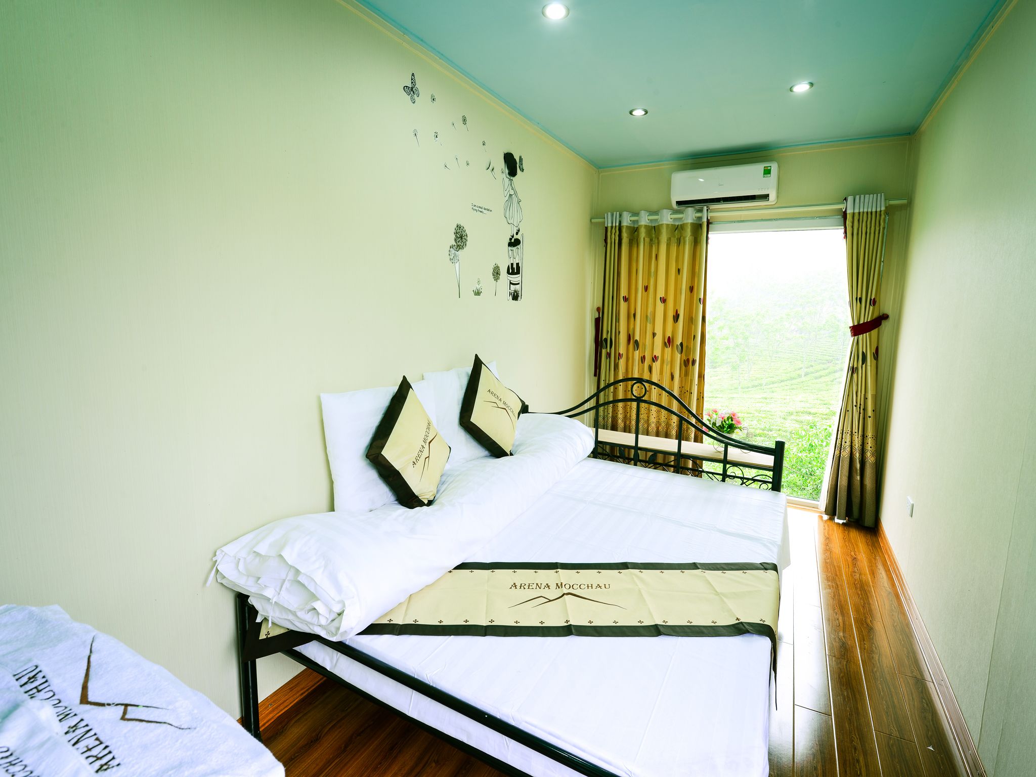 A bedroom with a bed, a window with curtains, and an air conditioning unit.