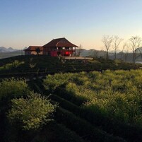 Un edificio con techo rojo y un porche cubierto en una ladera.