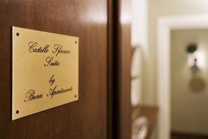 Una placa en una puerta de madera con el texto 'Castello Storero Suites by Brera Apartment'.