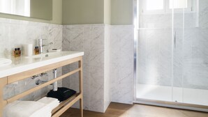 A modern bathroom with a marble sink, wooden vanity, and a glass shower enclosure. - Castello Sforzesco Suites by Brera Apartments (Milan)