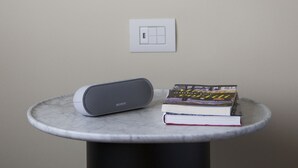A modern table with a Sony speaker and books, a white spherical light fixture, and a wall switch. - Castello Sforzesco Suites by Brera Apartments (Milan)
