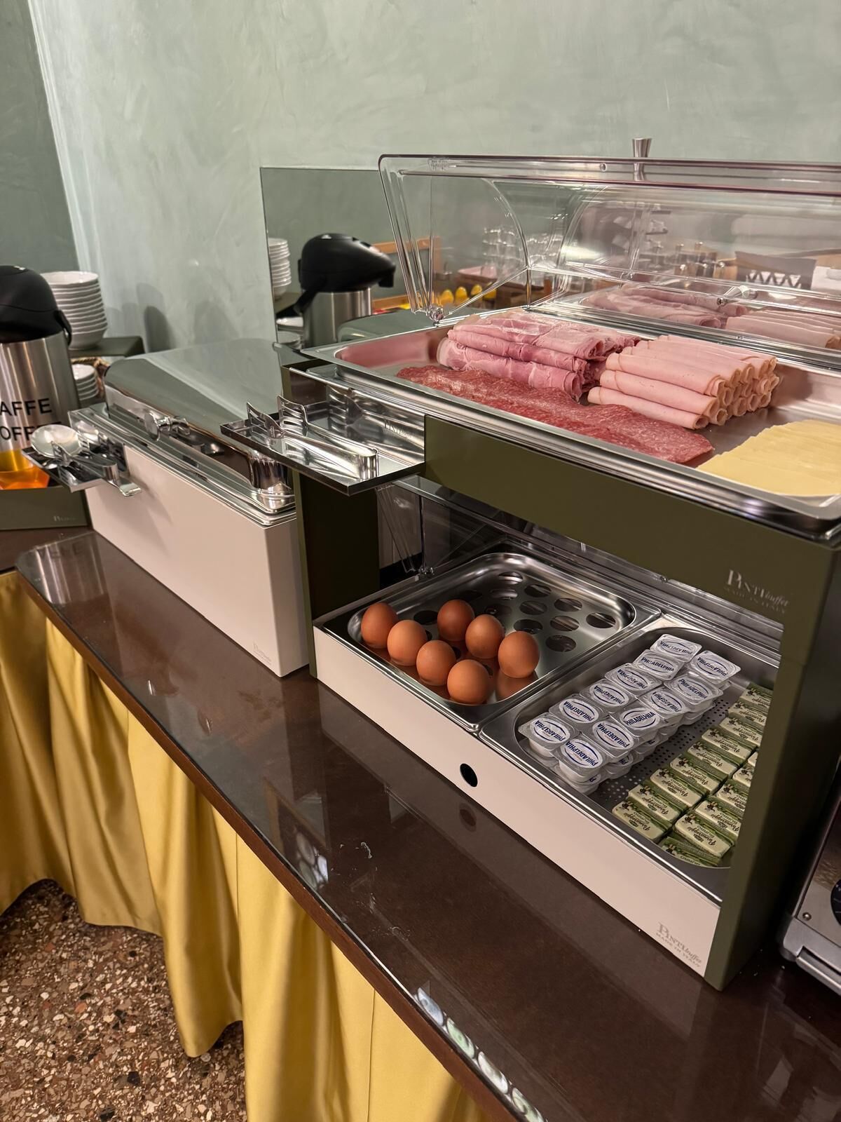 Un bufé con diversos alimentos, incluyendo carnes, huevos y productos lácteos.
