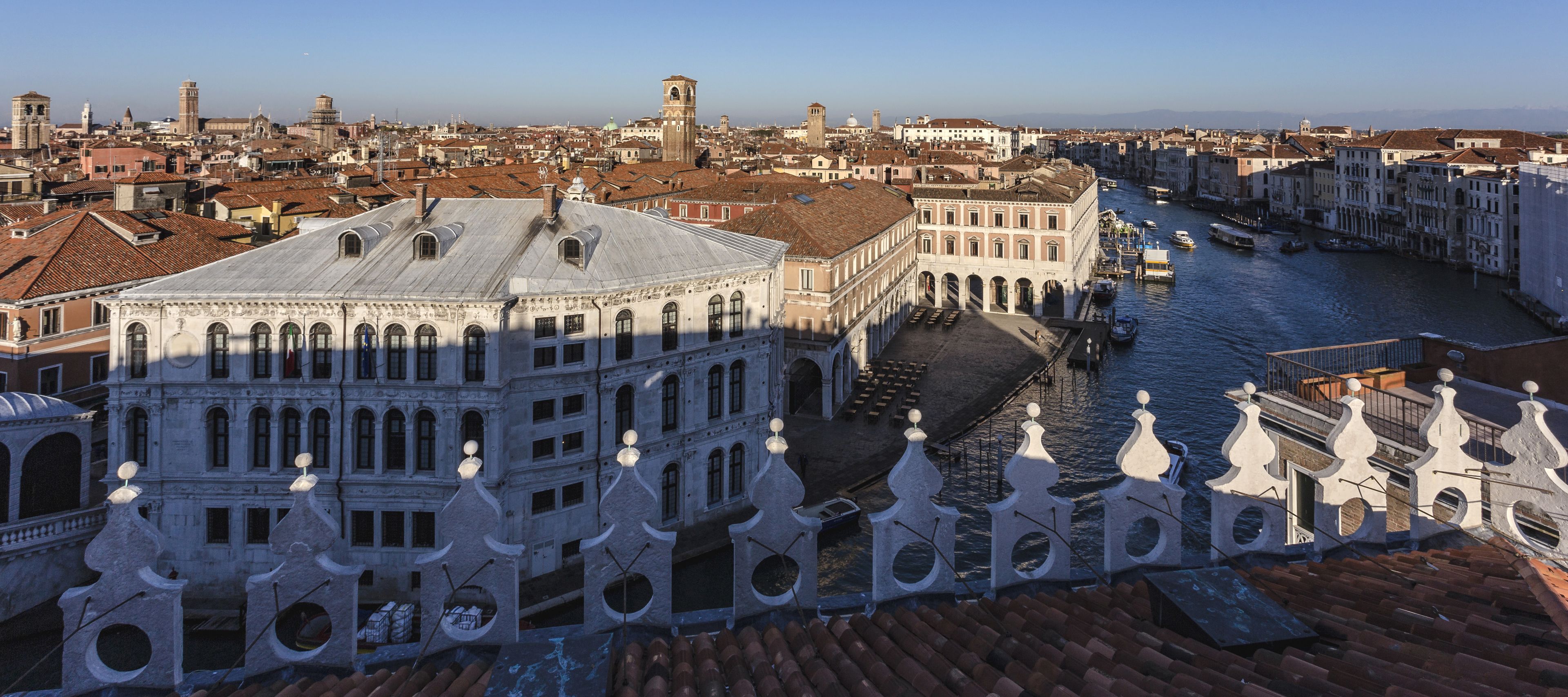A historic building with a central courtyard, a canal, and a view of the cityscape.